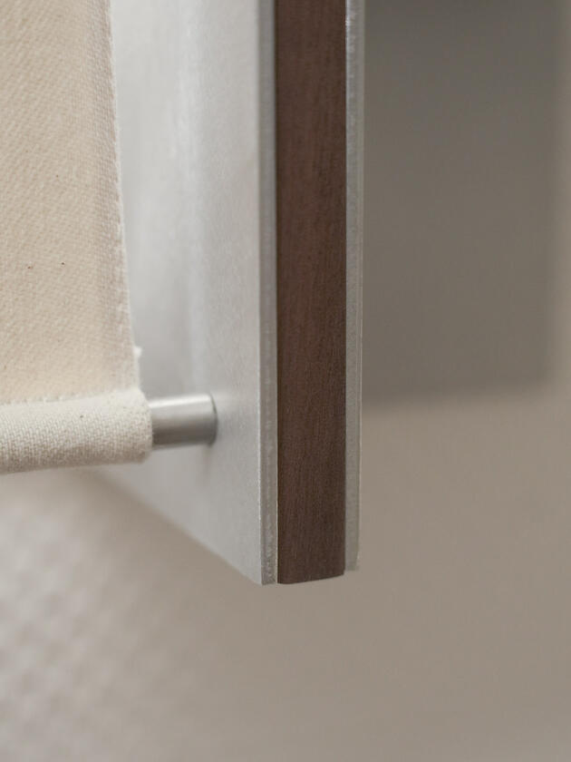 A wall lamp made of hand brushed aluminium with a strip of dark hardwood and a soft calico cover. Designed and made by Liam Barwick