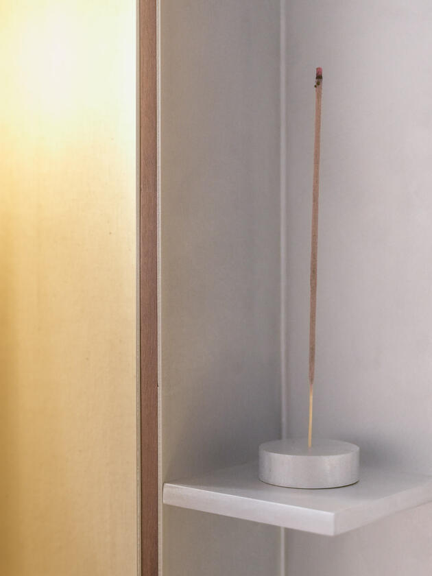A wall lamp made of hand brushed aluminium with a strip of dark hardwood and a soft calico cover. Designed and made by Liam Barwick