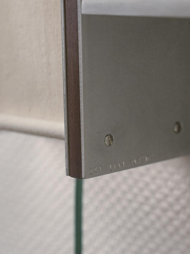 A wall lamp made of hand brushed aluminium with a strip of dark hardwood and a soft calico cover. Designed and made by Liam Barwick