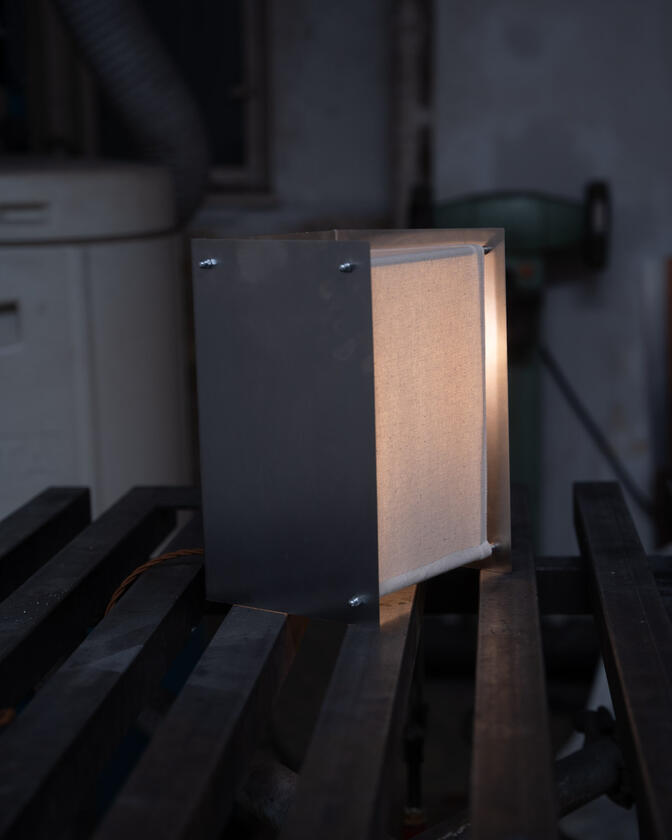 A table lamp constructed of a raw steel exterior and a soft organic cotton canvas diffuser. Designed and constructed by Liam Barwick
