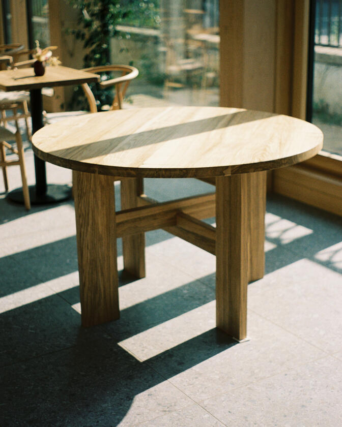 A large wooden round table 120cm in diameter made of solid ash wood. Designed and made by Liam Barwick