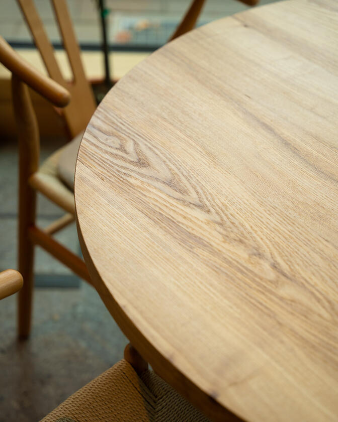A large wooden round table 120cm in diameter made of solid ash wood. Designed and made by Liam Barwick