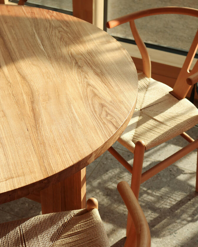A large wooden round table 120cm in diameter made of solid ash wood. Designed and made by Liam Barwick